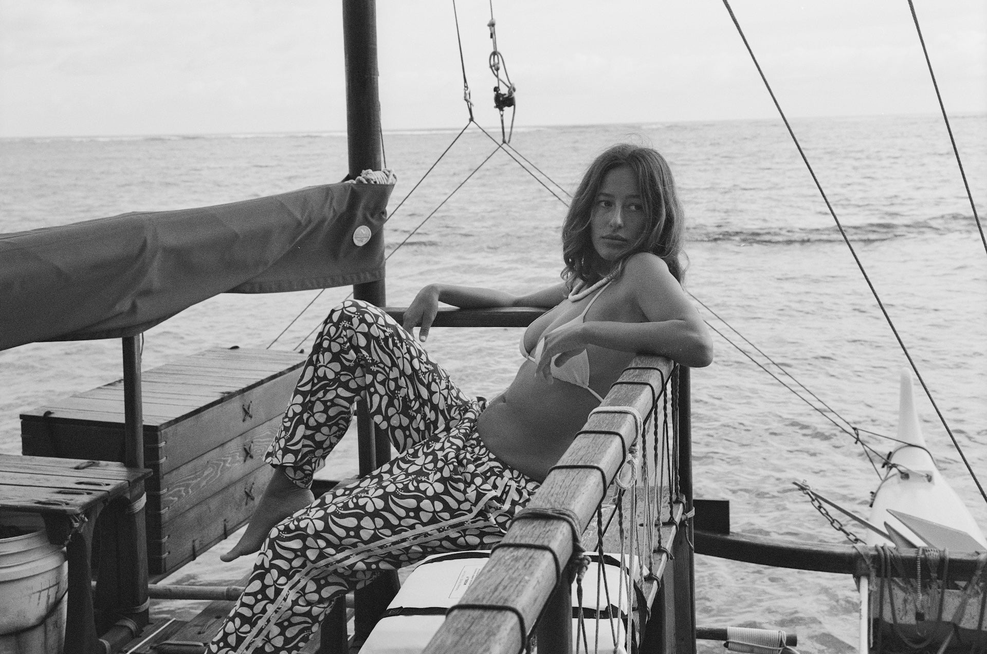 Woman sitting on a boat railing with a scenic background
